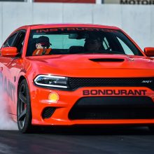 Drag Strip Showdown Winner doing a burnout in an orange Charger Hellcat