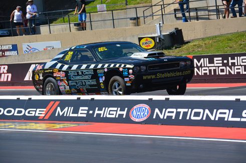 a vehicle covered in decals on the starting line of a drag strip