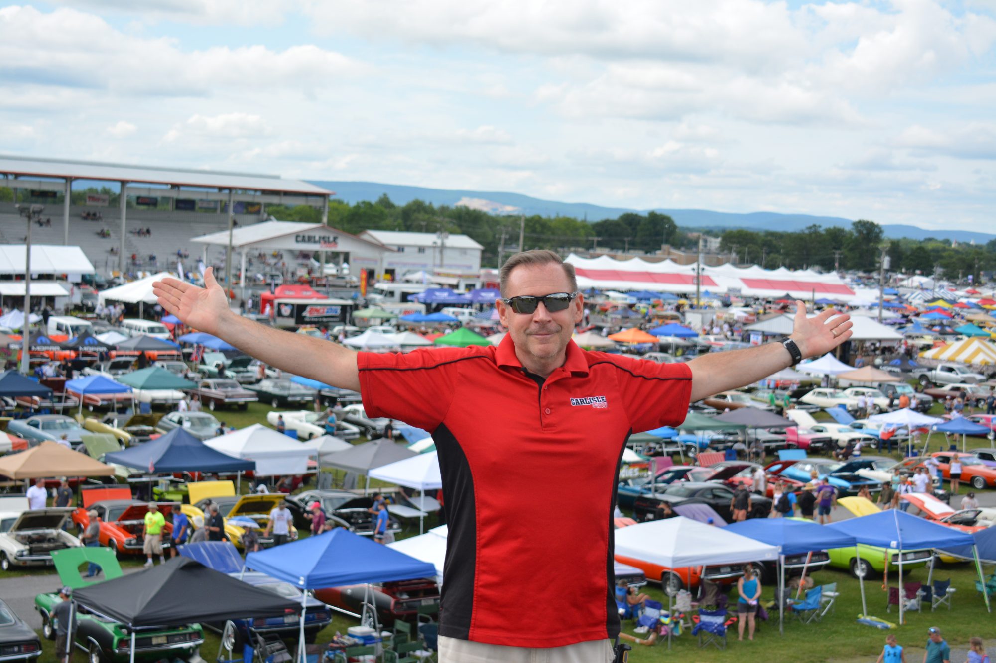 Man standing above a lot of vehicles on display