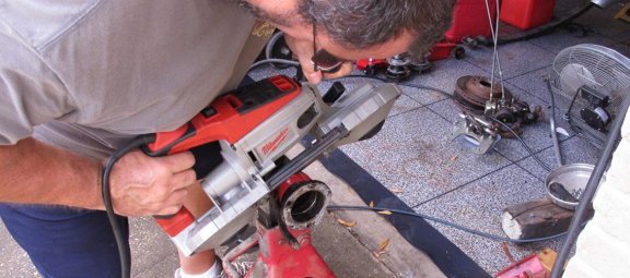 Man working on the rear-end of a Mopar vehicle